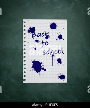 Piece of paper with inscription Back to school on chalk board Stock Photo