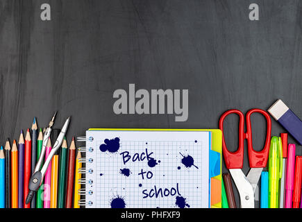 School suppiles on black board background. Stock Photo