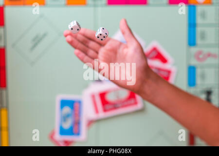 The hand throws game dice on the background of the playing field Stock Photo