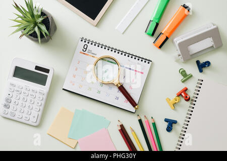 Business concept: stapler,markers, magnifier, cutter, tape, pen, pencil, clip, calculator, calendar and color pencil Stock Photo