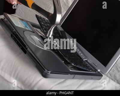 Computer laptop being smashed and destroyed with a hammer Stock Photo