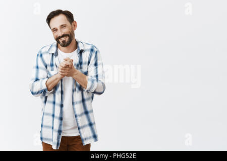 Appreciate you help, thanks. Touched and pleased charming business partner in checked shirt, clenching palms together and smiling broadly while being grateful for rescue over gray background Stock Photo