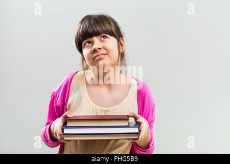 Angry little girl with books Stock Photo