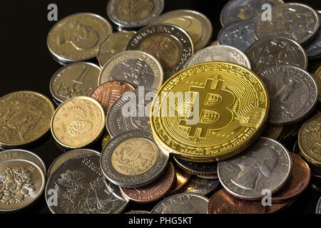 Golden bitcoin over a pile of coins. Stock Photo