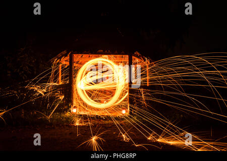 Long exposure image of steel wool photography, light painting in wooden house. Stock Photo