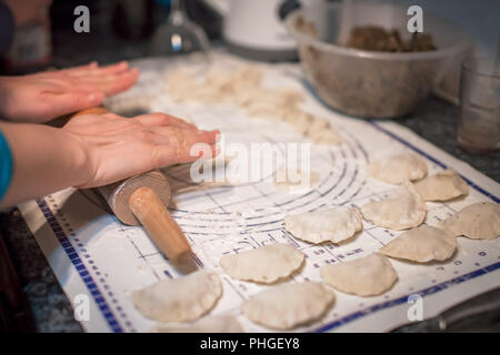 Woman preparing pierogi in the kitchen Stock Photo