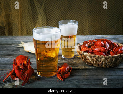 Tasty boiled crayfishes and beer on old table Stock Photo