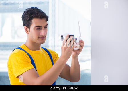 Contractor installing surveillance CCTV cameras in office Stock Photo