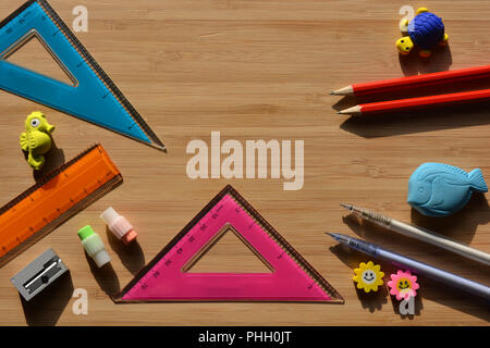 Pencils, erasers, ruler, sharpener and set squares on a wooden desktop with copy space, back to school math essentials. Flatlay photography Stock Photo