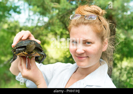 Pretty blond woman holding a turtle Stock Photo