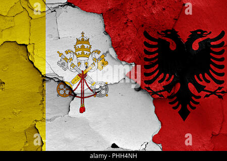 flag of Vatican and Albania painted on cracked wall Stock Photo