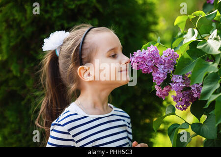Girl smelling lilac flowers Stock Photo
