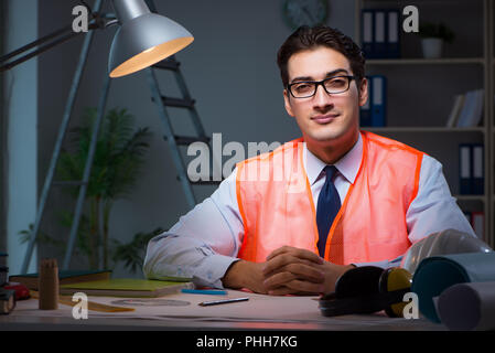 Construction architect working on drawings late at night Stock Photo