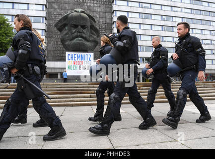 Chemnitz, Germany. 01st Sep, 2018. 01.09.2018, Saxony, Chemnitz: Police march past the Karl Marx Monument. Photo: Ralf Hirschberger/dpa/Alamy Live News