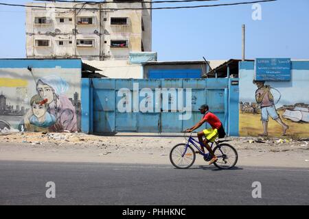 September 1, 2018 - Gaza City, Gaza Strip, Palestinian Territory - A Palestinian man rides a bicycle past relief and services program office run by United Nations Relief and Works Agency (UNRWA), at Al-Shati refugee camp, in Gaza City on September 1, 2018. The United States on Friday halted all funding to United Nations' agency that helps Palestinian refugees. State Department spokeswoman Heather Nauert said the business model and fiscal practices of the United Nations Relief and Works Agency (UNRWA) made it an 'irredeemably flawed operation (Credit Image: © Mahmoud Ajour/APA Images via ZUM Stock Photo