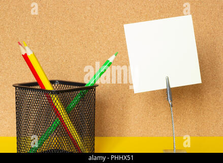 Stickers and colored pencils on the background of a cork board, copy space Stock Photo