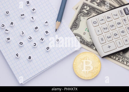 Close-up, on a white background calculator, money (bitcoin) and notepad with letters Stock Photo