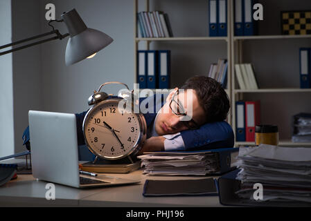 Businessman falling asleep during long hours in office Stock Photo