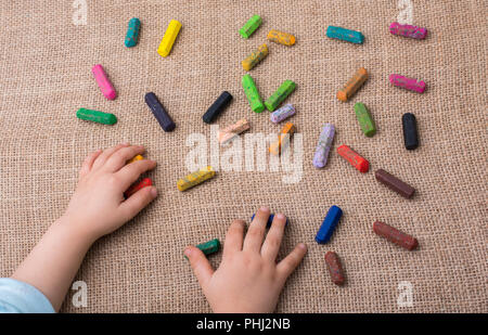 Used  color crayons and a toddlers hand Stock Photo