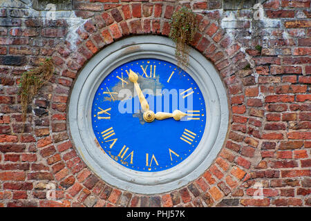 Old outside built in wall clock with roman numerals Stock Photo