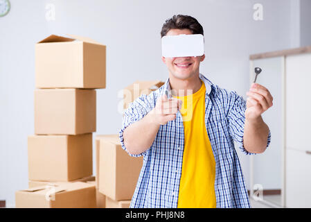 Young man wearing VR glasses moving in new apartment Stock Photo
