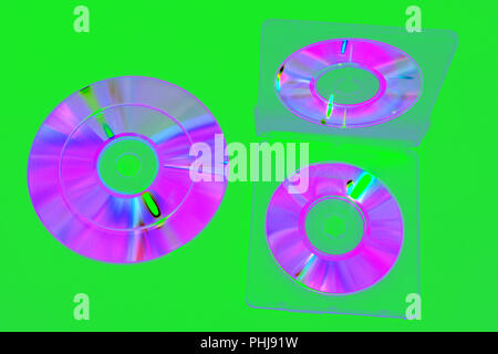 image in complementary colors tones : double-sided plastic box for mini CDs, open. iridescent compact discs on green background. with clipping pass Stock Photo