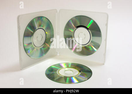double-sided transflective white case for storing mini discs with blank cds on clamps and lying next disc with reflecting surface Stock Photo