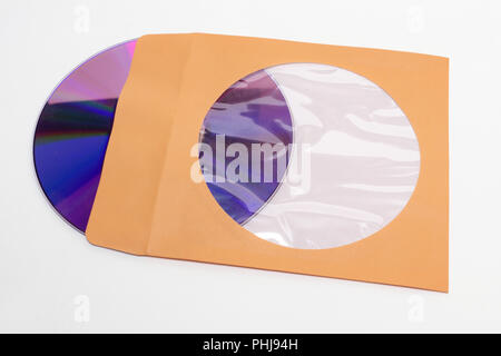 DVD compact disc sticking out of orange paper envelope with flap and coated round hole to see content inside; with clipping path Stock Photo