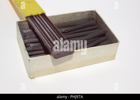 graphite drawing set soft and hard equipment: cases with modern monolith woodless graphite pencils and retro charcoal large sticks Stock Photo
