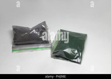 powder colorant for fabric. Two re-sealable plastic packs, closed on grip lock, with dark colors inside; with clipping path Stock Photo