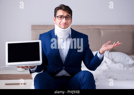 Businessman with neck injury working from home Stock Photo