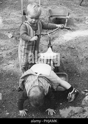 1946s children. Two boys are playing with a tricycle. Sweden 1960s Stock Photo