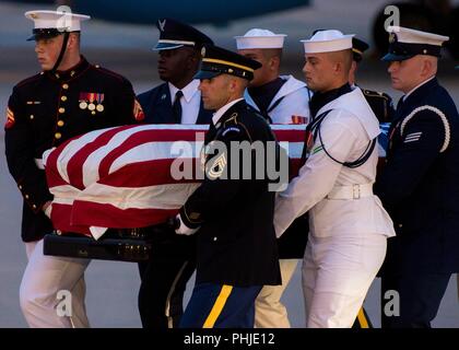 A U.S. Military Joint Service honor guard carries the flag-draped casket of Sen. John S. McCain III after arrival from Arizona August 30, 2018 at Joint Base Andrews, Maryland. The former senator’s remains are en route to lie in state in the U.S. Capitol Rotunda before burial at the U.S. Naval Academy. Stock Photo