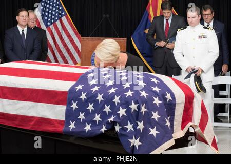 Cindy McCain lays her head on the casket of her husband, Sen. John McCain, laying in state at the Arizona State Capitol August 29, 2018 in Phoenix, Arizona. The former senator’s remains will lie in state in the U.S. Capitol Rotunda before burial at the U.S. Naval Academy. Stock Photo