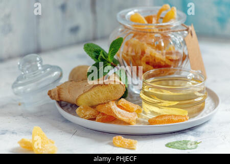 Hot ginger tea and slices of candied ginger. Stock Photo