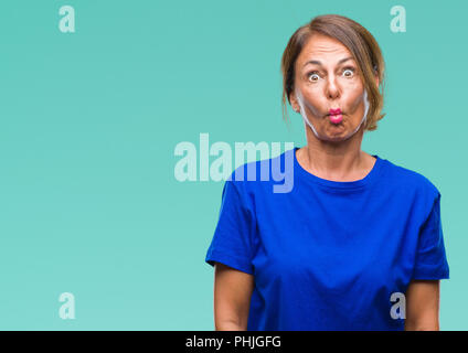 Middle age senior hispanic woman over isolated background making fish face with lips, crazy and comical gesture. Funny expression. Stock Photo