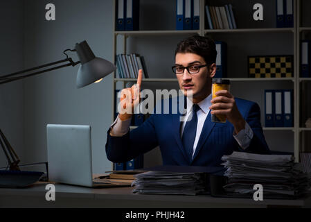 Employee working late and drinking strong coffee to stay awake Stock Photo
