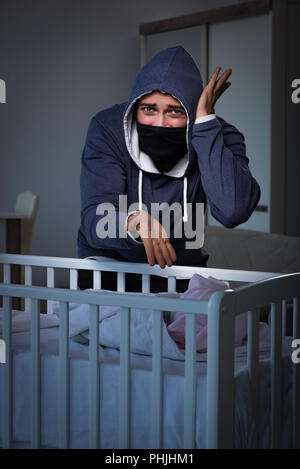 Criminal stealing baby in human child traficking concept Stock Photo