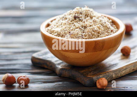 Hazelnut flour in a wooden bowl. Stock Photo