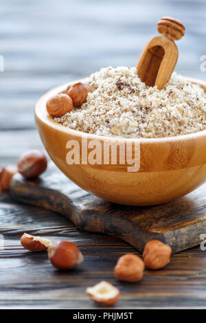 Hazelnut flour and wooden scoop in a bowl. Stock Photo