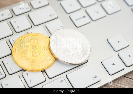 Golden and silver bitcoins on a keyboard Stock Photo