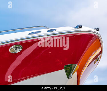 detail image of a the bow of a red and white fiberglass boat against a blue sky Stock Photo