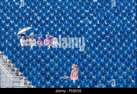 a group of people sitting in bleachers Stock Photo