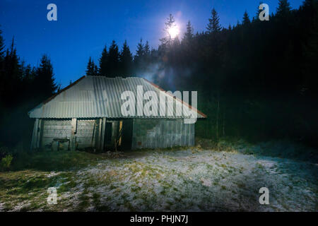 Old house in forest at night Stock Photo