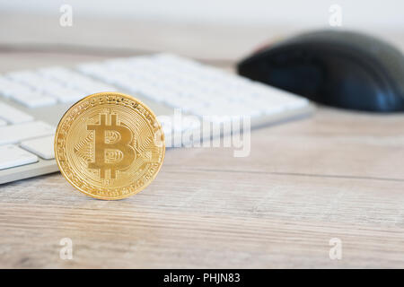 Golden bitcoin on a wooden desk Stock Photo