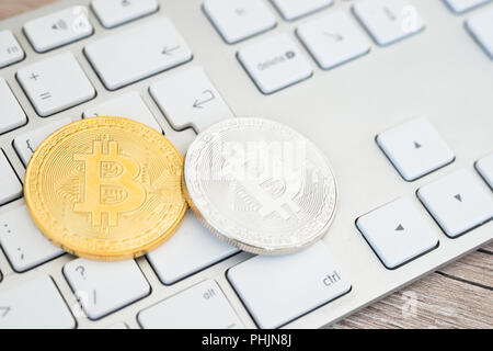 Golden and silver bitcoins on a keyboard Stock Photo