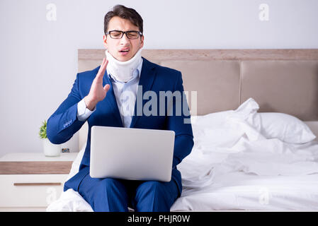 Businessman with neck injury working from home Stock Photo