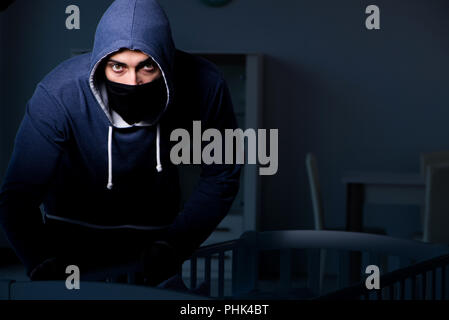 Criminal stealing baby in human child traficking concept Stock Photo