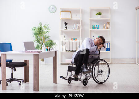 Doctor resting on wheelchair in hospital after night shift Stock Photo