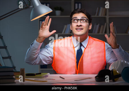 Construction architect working on drawings late at night Stock Photo